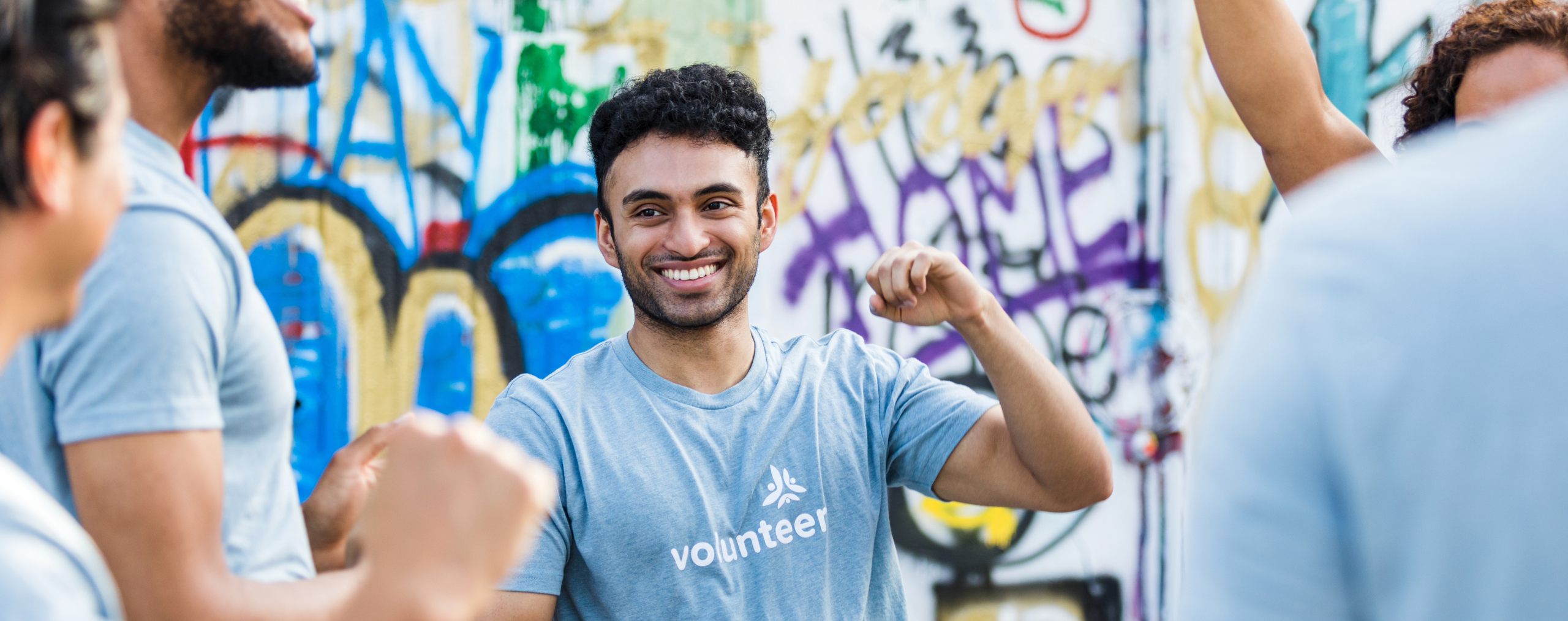 A male charity volunteer, smiling and dancing